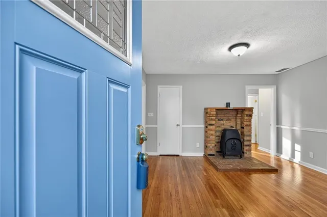 a view of empty room with a fireplace and wooden floor