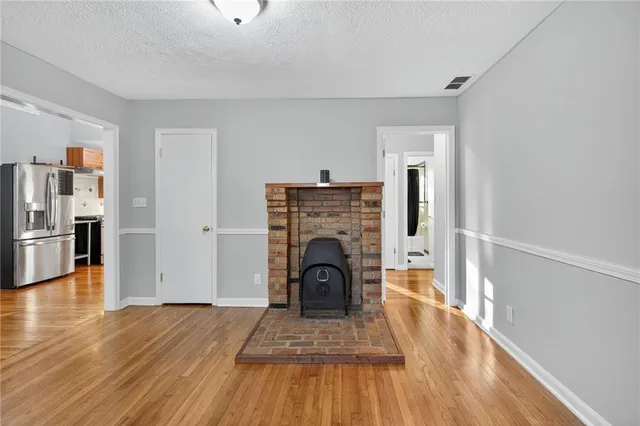 a view of a livingroom with a fireplace wooden floor and a window
