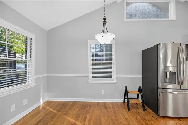 a view of a room with wooden floor a ceiling fan and windows