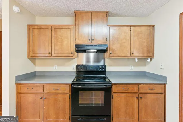 a kitchen with granite countertop white cabinets and stainless steel appliances