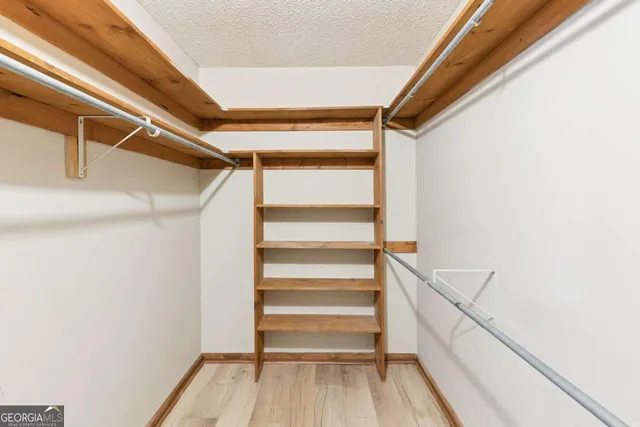 a view of walk in closet with empty racks
