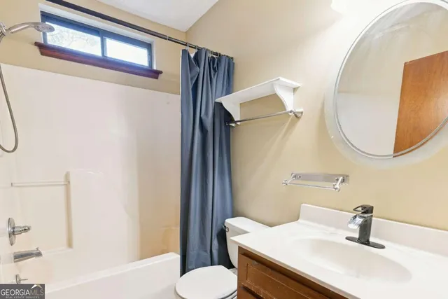 a bathroom with a sink mirror vanity and toilet