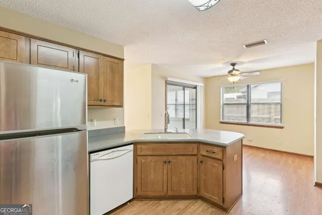a kitchen with white cabinets and refrigerator