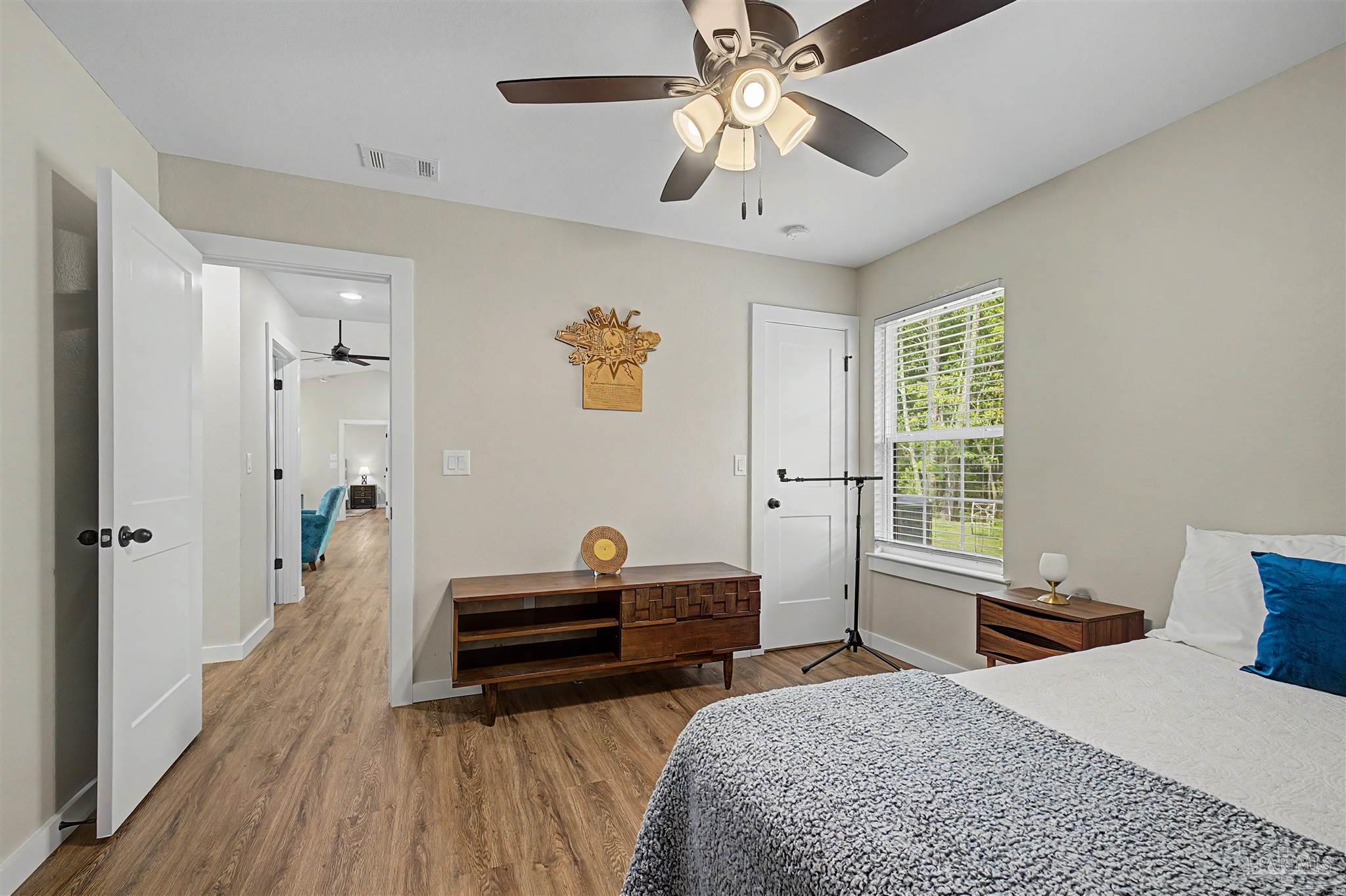 2549 Ten Mile Road Pace, FL 32571 - Photo 25 of 46 a bedroom with a bed and a chandelier