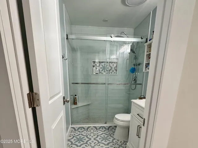 a bathroom with a toilet and a shower