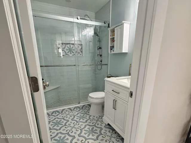 a bathroom with a granite countertop shower and a toilet