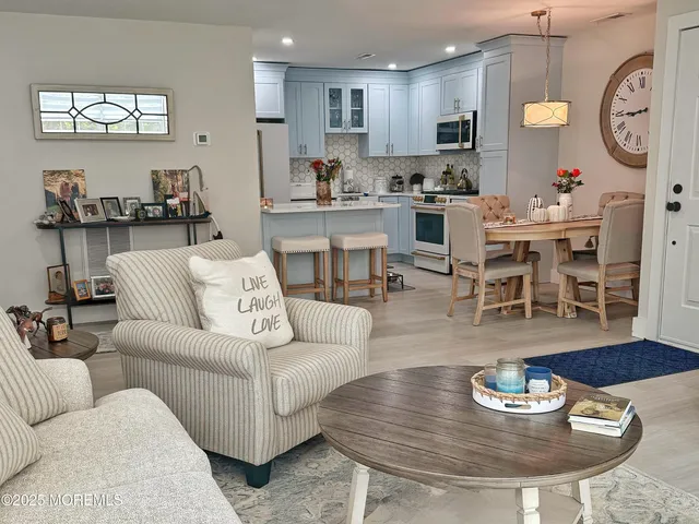 a living room with furniture and a dining table with kitchen view