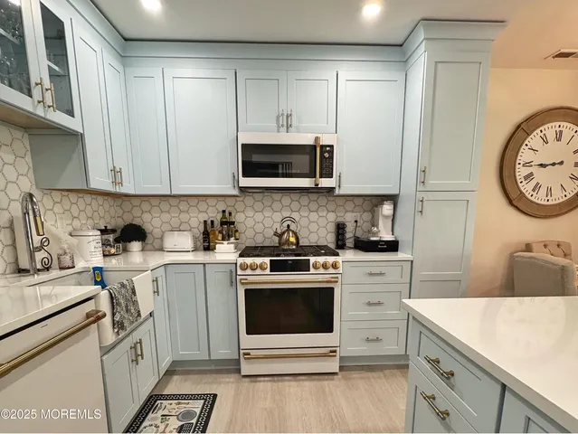 a kitchen with a stove white cabinets and a sink