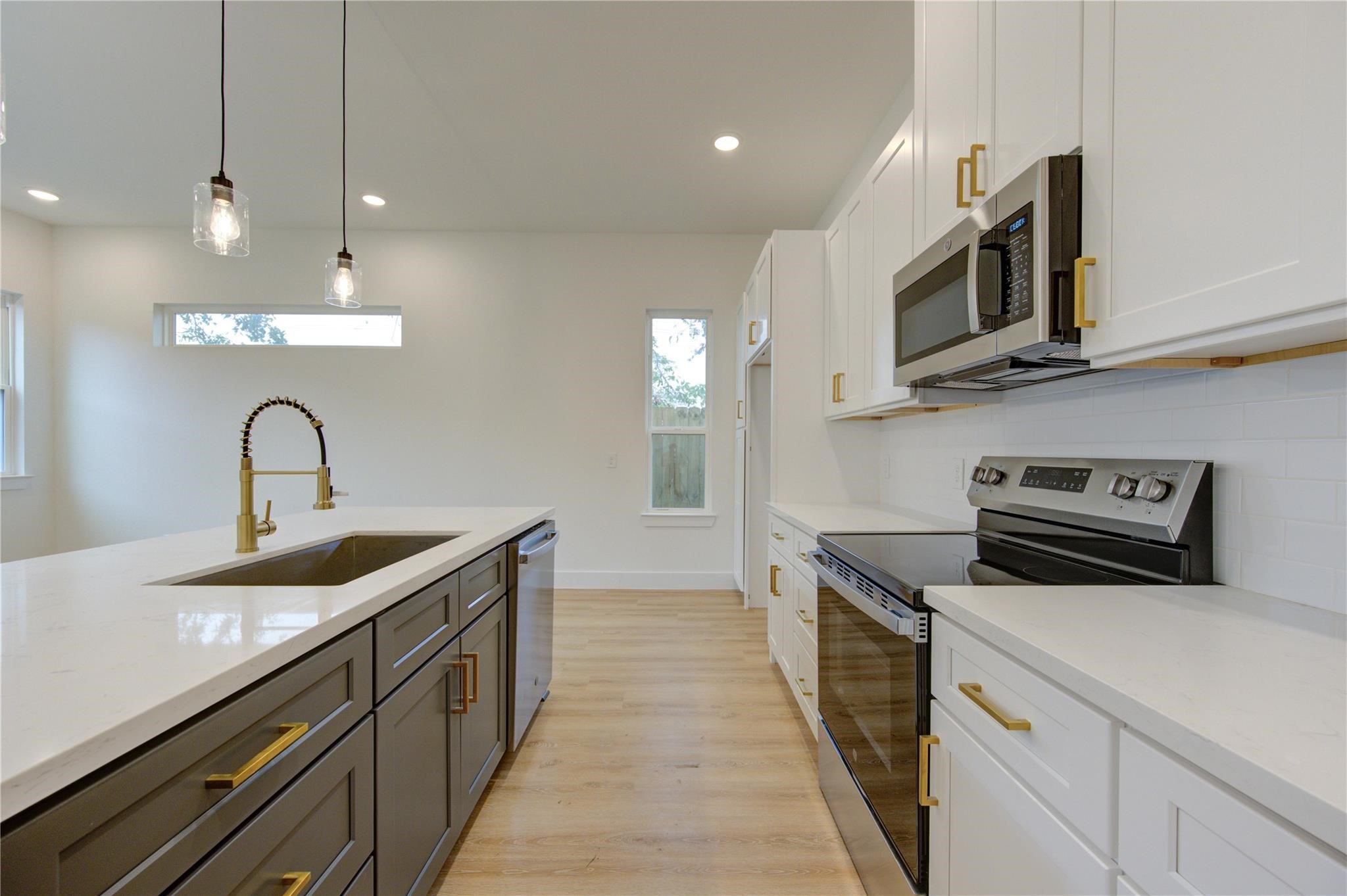 a kitchen with stainless steel appliances a stove microwave and sink