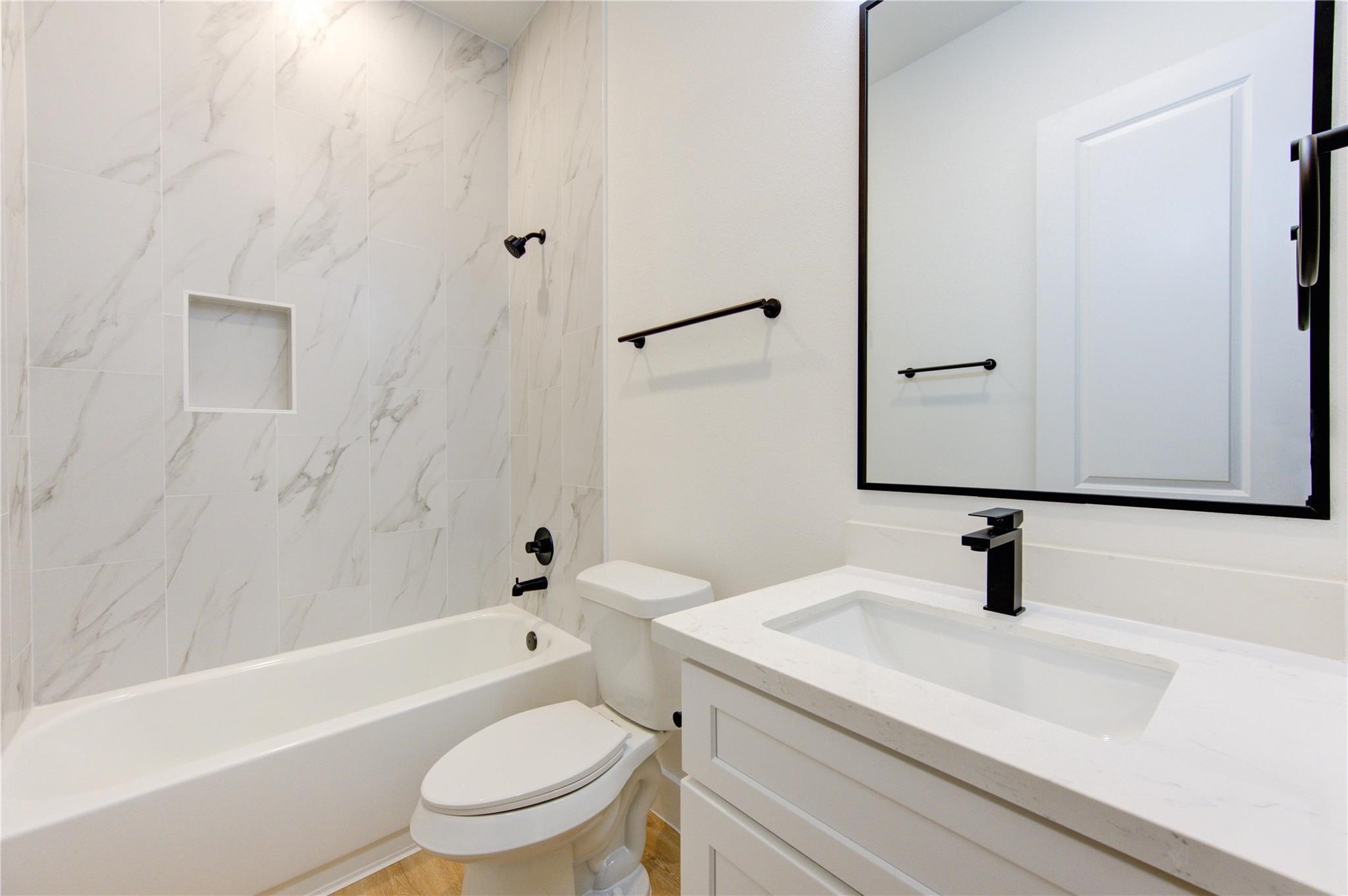 4029 Knoxville Street, Unit B Houston, TX 77051 - Photo 13 of 33 a bathroom with a sink a toilet a mirror and shower