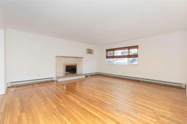 an empty room with wooden floor and a window