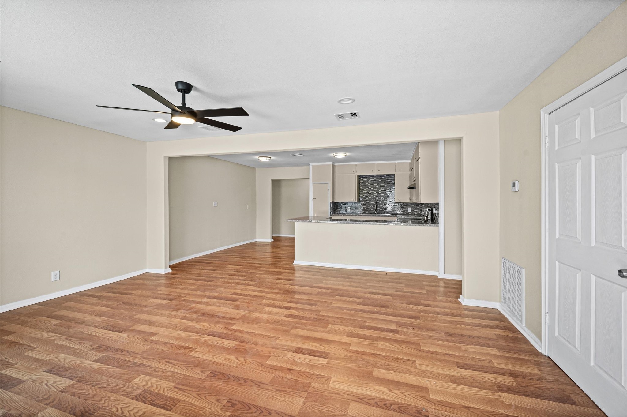 10621 Lane Street Houston, TX 77029 - Photo 4 of 29 a view of kitchen and empty room with wooden floor
