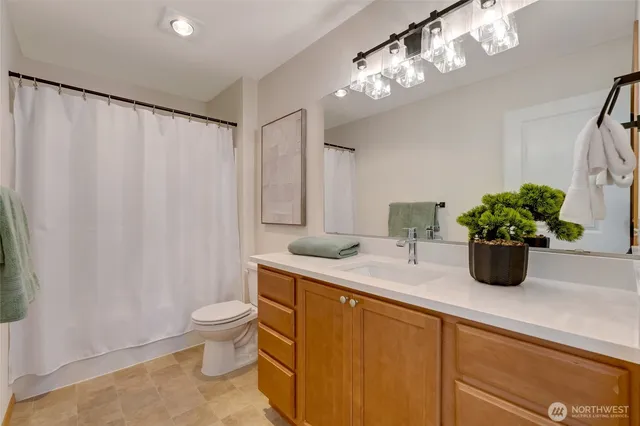 a bathroom with a granite countertop sink a toilet and a mirror