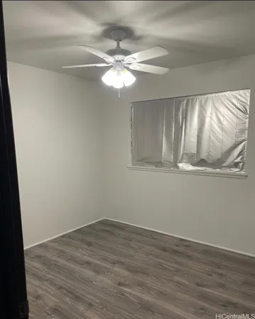 a view of a room with wooden floor and fan