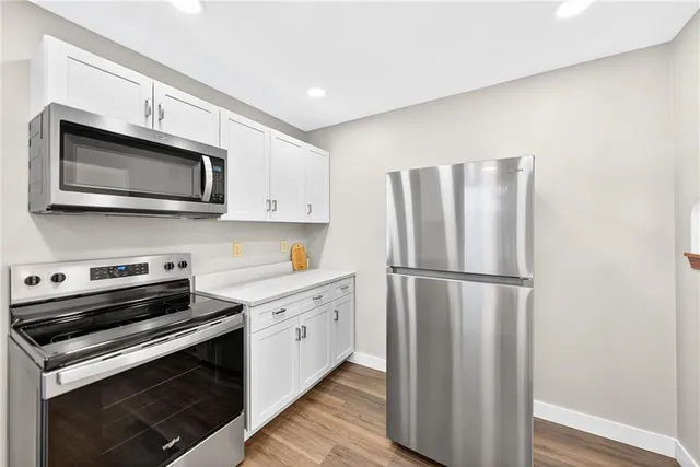 a kitchen with stainless steel appliances a stove microwave and refrigerator