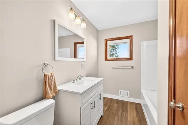 a bathroom with a sink a toilet and a mirror