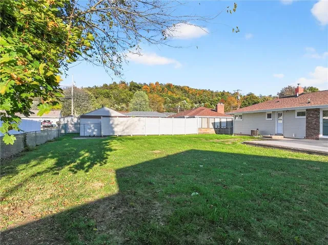 a view of yard with swimming pool and green space