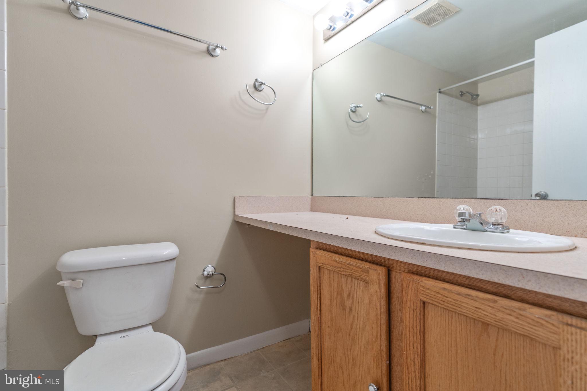 9653 White Acre Road, Unit B2 Columbia, MD 21045 - Photo 19 of 28 a bathroom with a granite countertop toilet sink and mirror