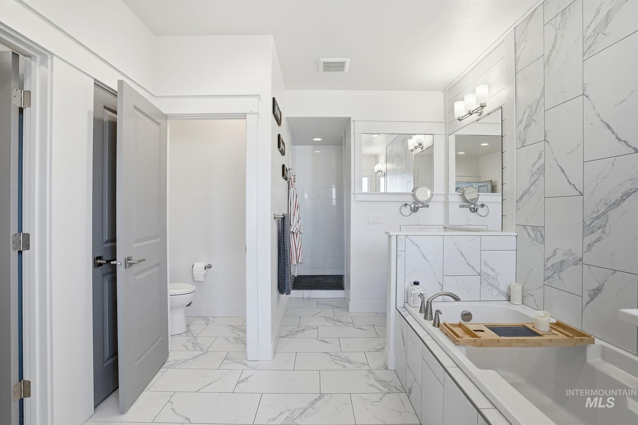 2301 Nordic Avenue Middleton, ID 83644 - Photo 19 of 50 Bathroom featuring light marble finish floors, a walk in shower, and a garden tub