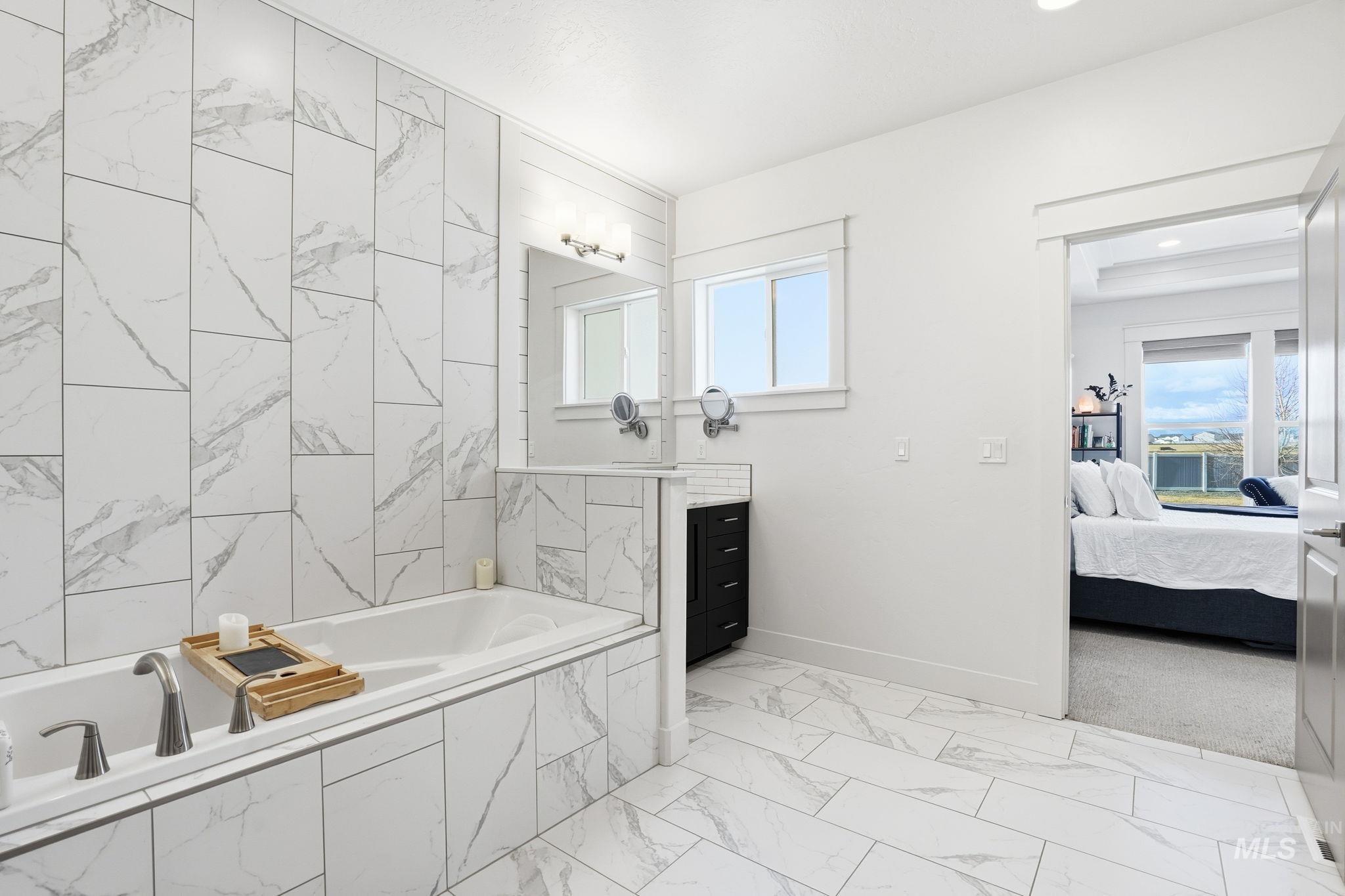 2301 Nordic Avenue Middleton, ID 83644 - Photo 20 of 50 Bathroom with connected bathroom, vanity, a bath, and light marble finish floors