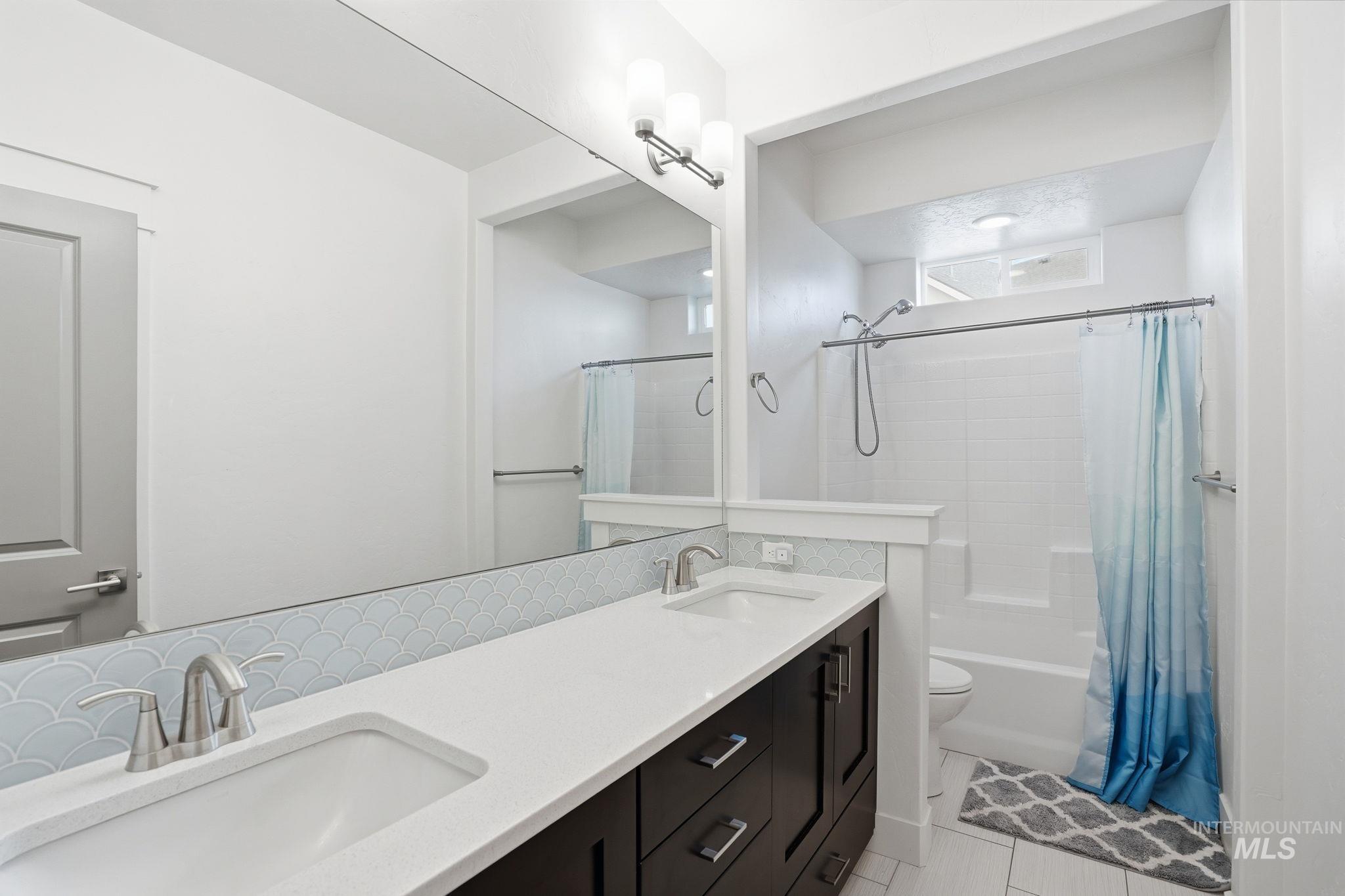 2301 Nordic Avenue Middleton, ID 83644 - Photo 34 of 50 Full bathroom with double vanity, shower / bath combo with shower curtain, and tasteful backsplash