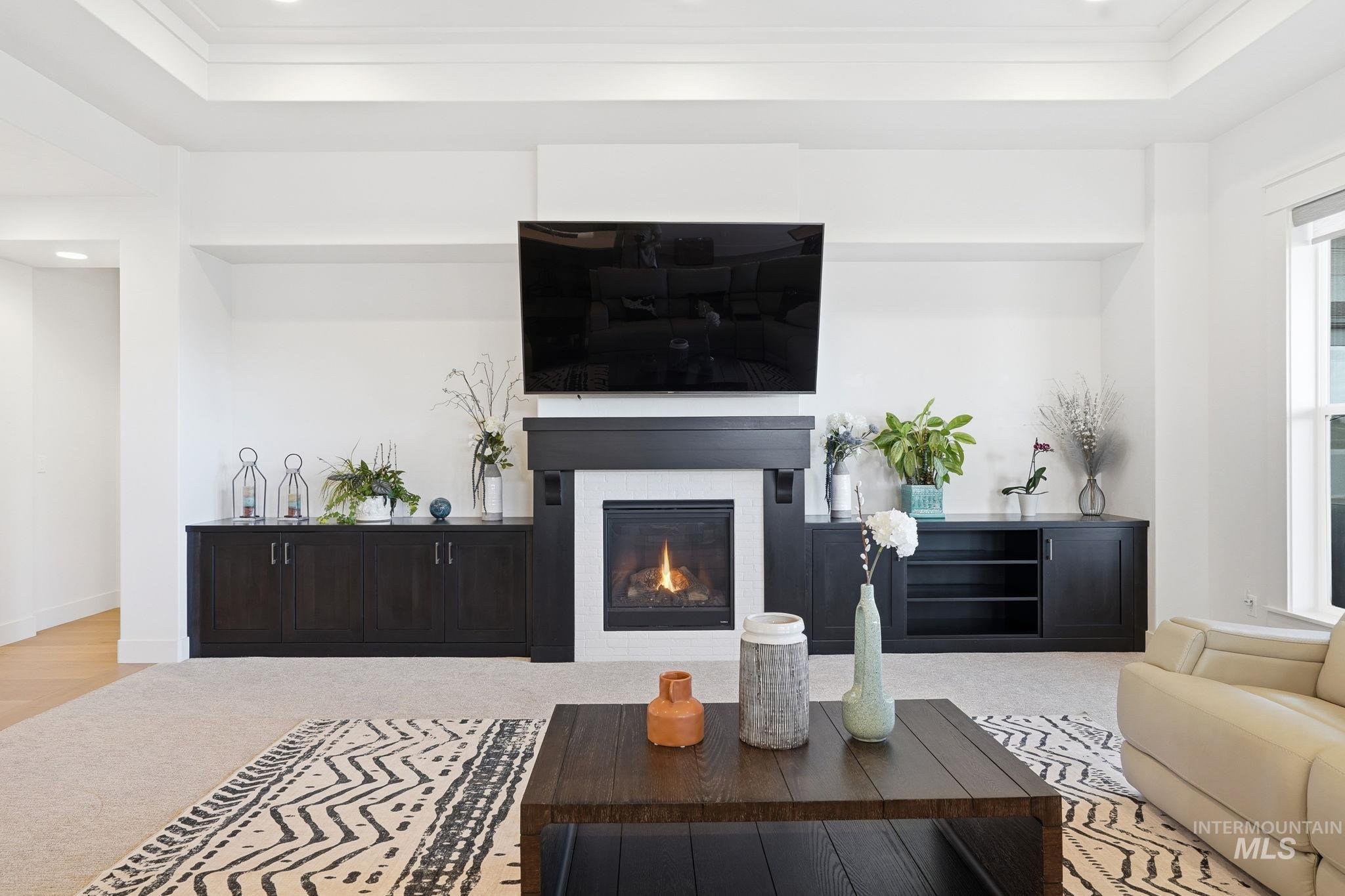 2301 Nordic Avenue Middleton, ID 83644 - Photo 6 of 50 Living room featuring recessed lighting, a raised ceiling, a glass covered fireplace, and ornamental molding