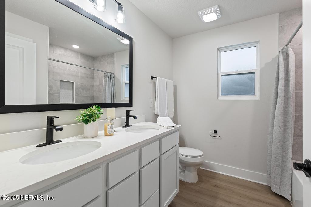 5124 Parete Road South Jacksonville, FL 32218 - Photo 37 of 42 a bathroom with a double vanity sink toilet and mirror