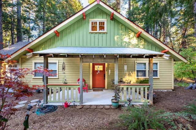 a front view of house with yard and trees in the background