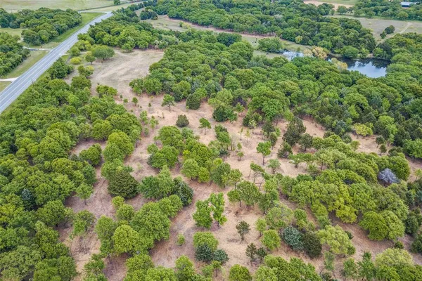 an aerial view of residential houses with outdoor space and trees