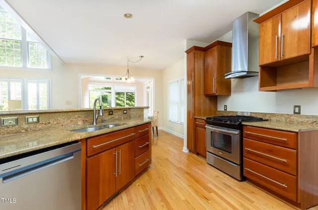 a kitchen with stainless steel appliances granite countertop a sink stove and refrigerator