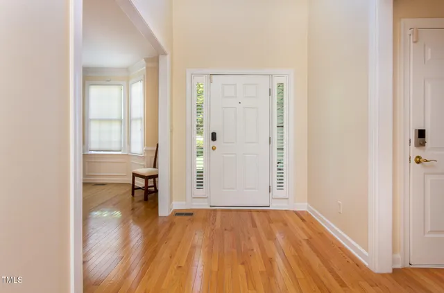 an empty room with wooden floor and a bathroom