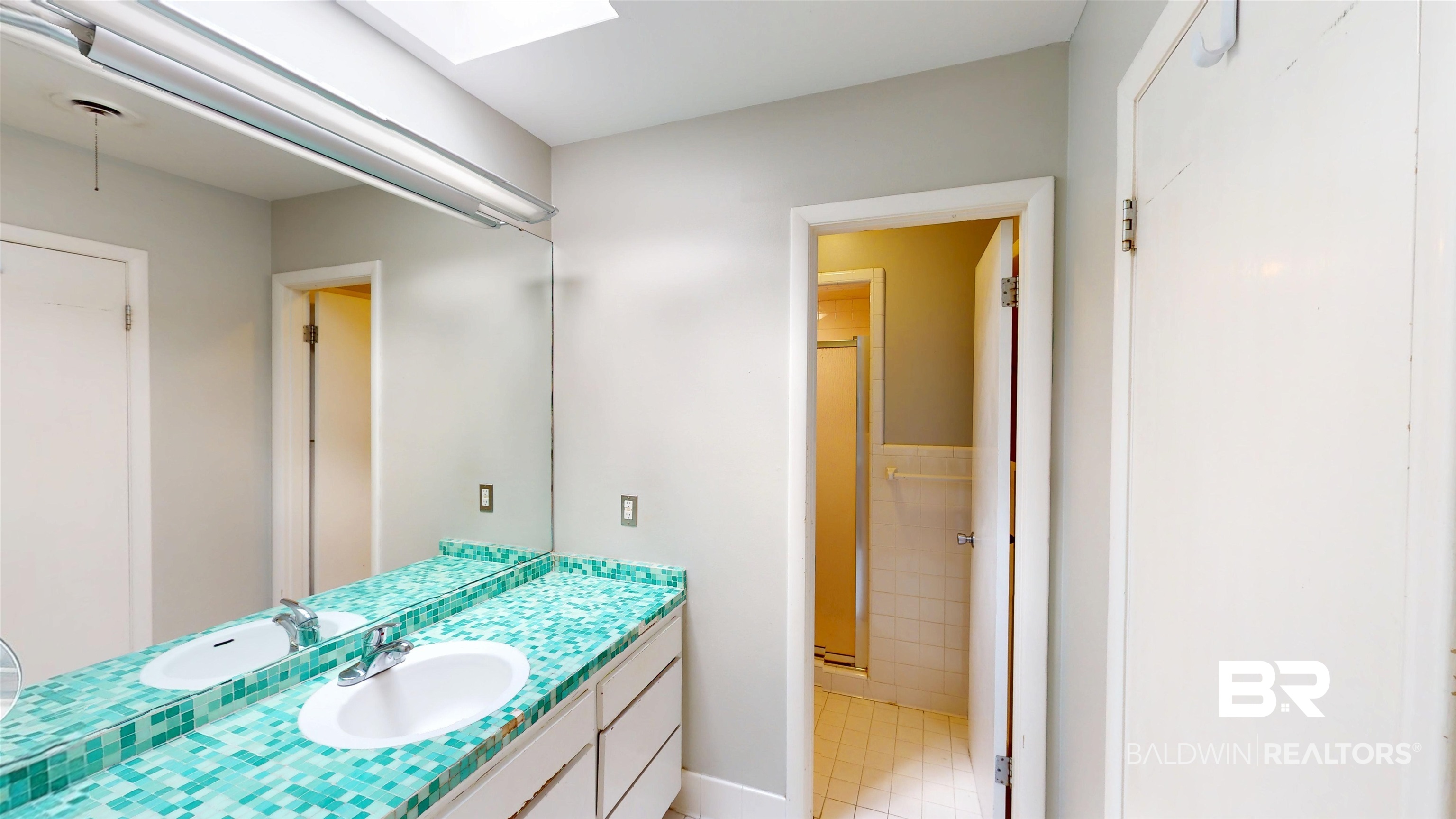 15 Spring Bank Road Mobile, AL 36608 - Photo 48 of 58 Bathroom with vanity, a skylight, light tile patterned floors, a shower stall, and tile walls