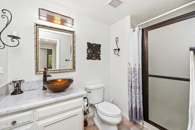 a bathroom with a granite countertop sink toilet and shower