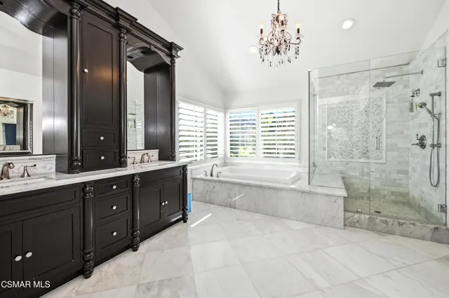 a spacious bathroom with a tub sink shower and mirror