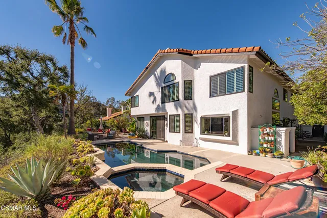 a view of a house with backyard and sitting area