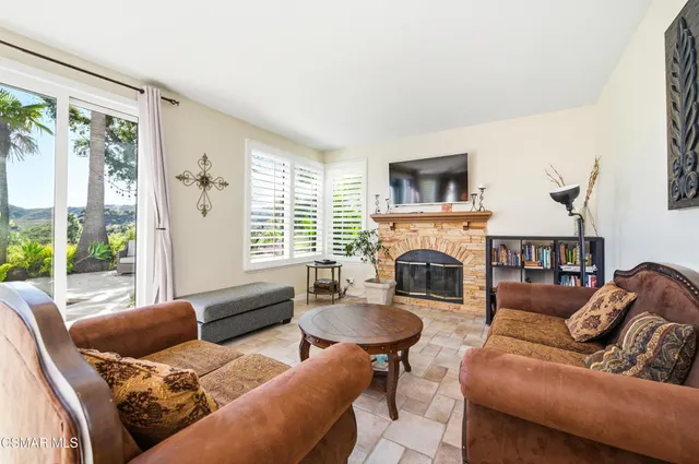 a living room with furniture fireplace and a large window