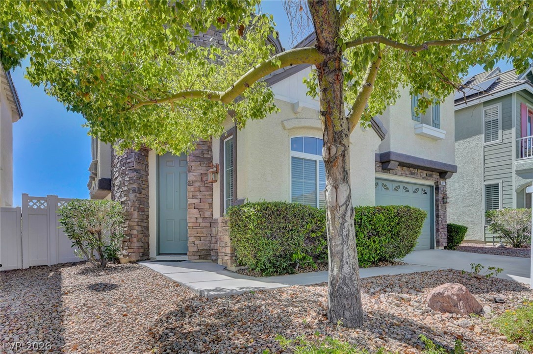 977 Sparkling Light Street Henderson, NV 89052 - Photo 15 of 75 This charming home offers a welcoming entrance with mature landscaping and a well-maintained exterior.