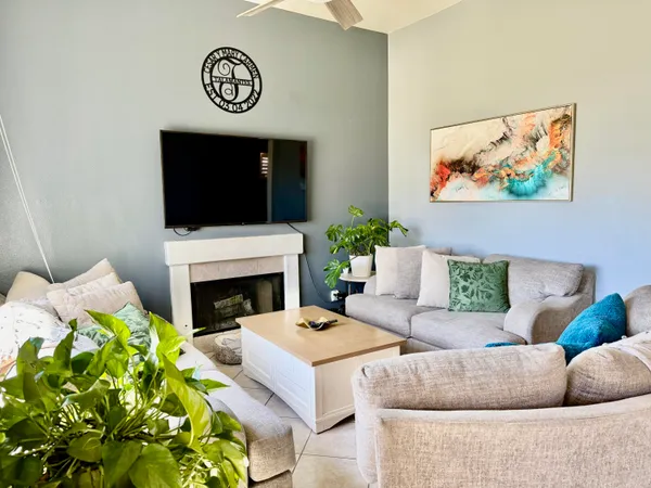 a living room with furniture a fireplace and a flat screen tv