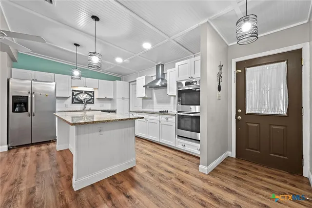 a large kitchen with stainless steel appliances kitchen island a large counter space a sink and appliances
