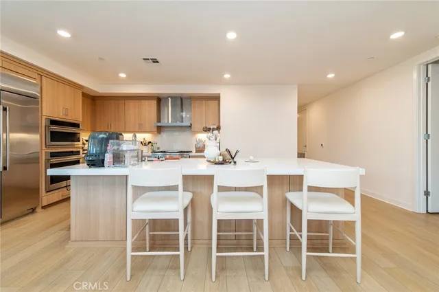a kitchen with kitchen island granite countertop wooden floor cabinets and stainless steel appliances