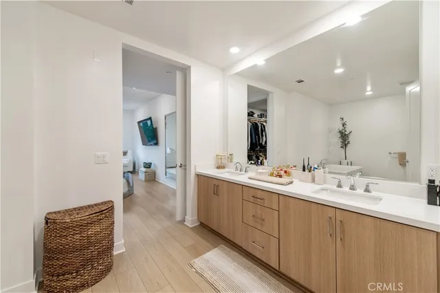 a spacious bathroom with a double vanity sink a mirror and a bathtub