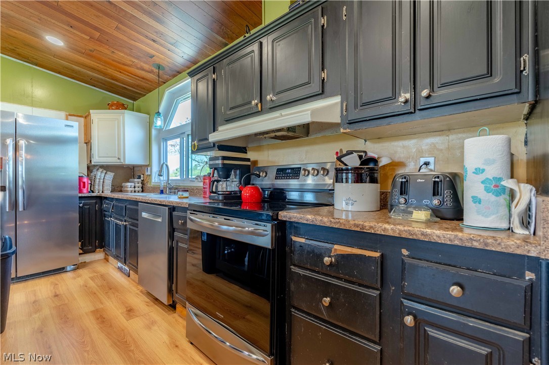 5267 Apollo Road Northeast Salineville, OH 43945 - Photo 8 of 33 Kitchen featuring appliances with stainless steel finishes, tasteful backsplash, wood ceiling, light wood finished floors, and under cabinet range hood