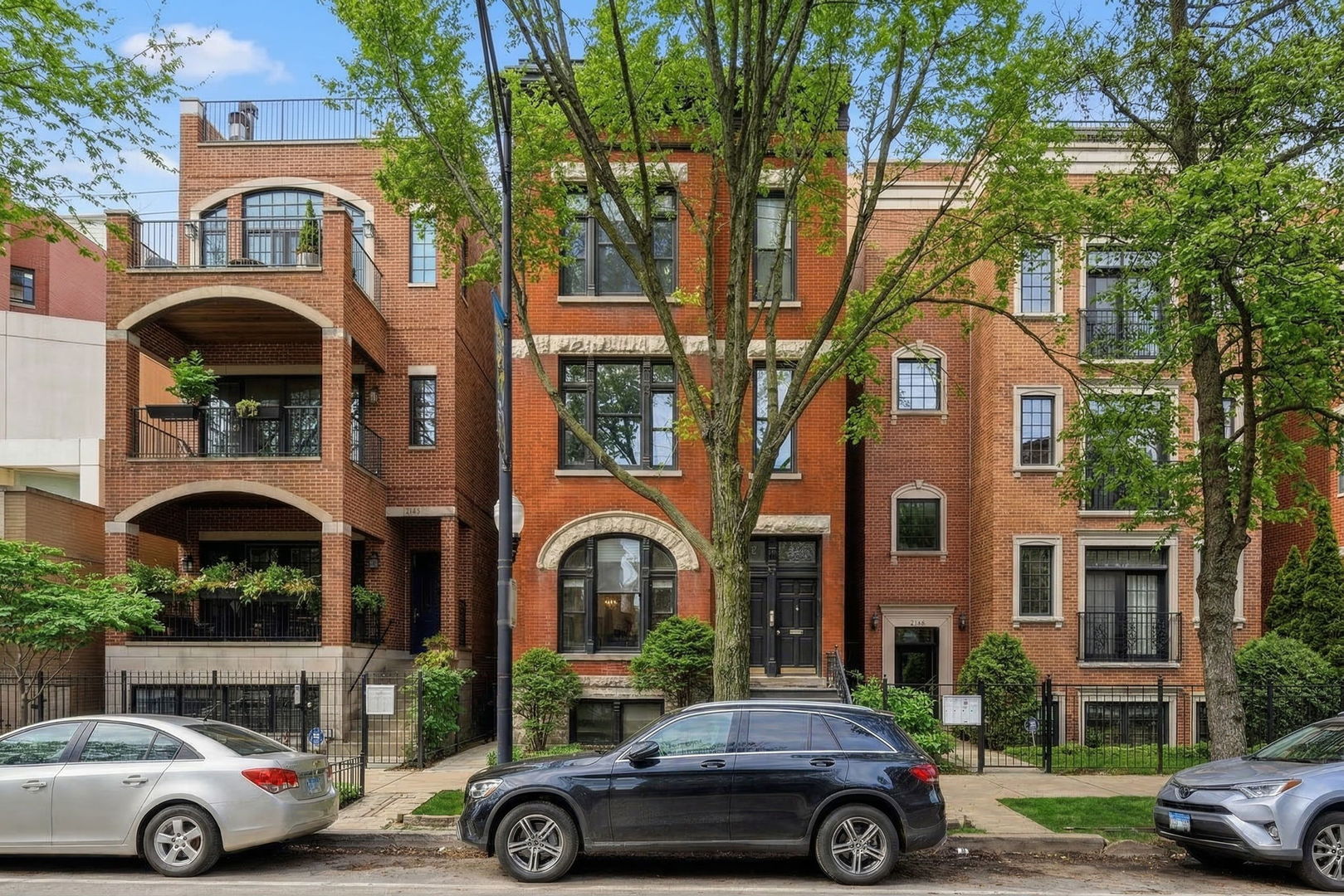 a front view of a residential apartment building with parking space