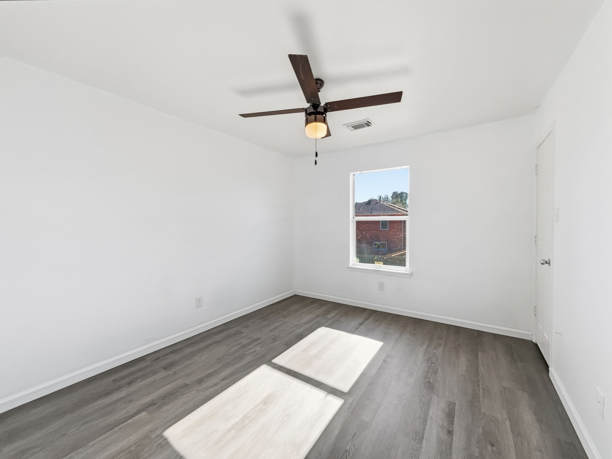 4907 Fox Mill Lane Spring, TX 77389 - Photo 13 of 18 an empty room with wooden floor ceiling fan and windows