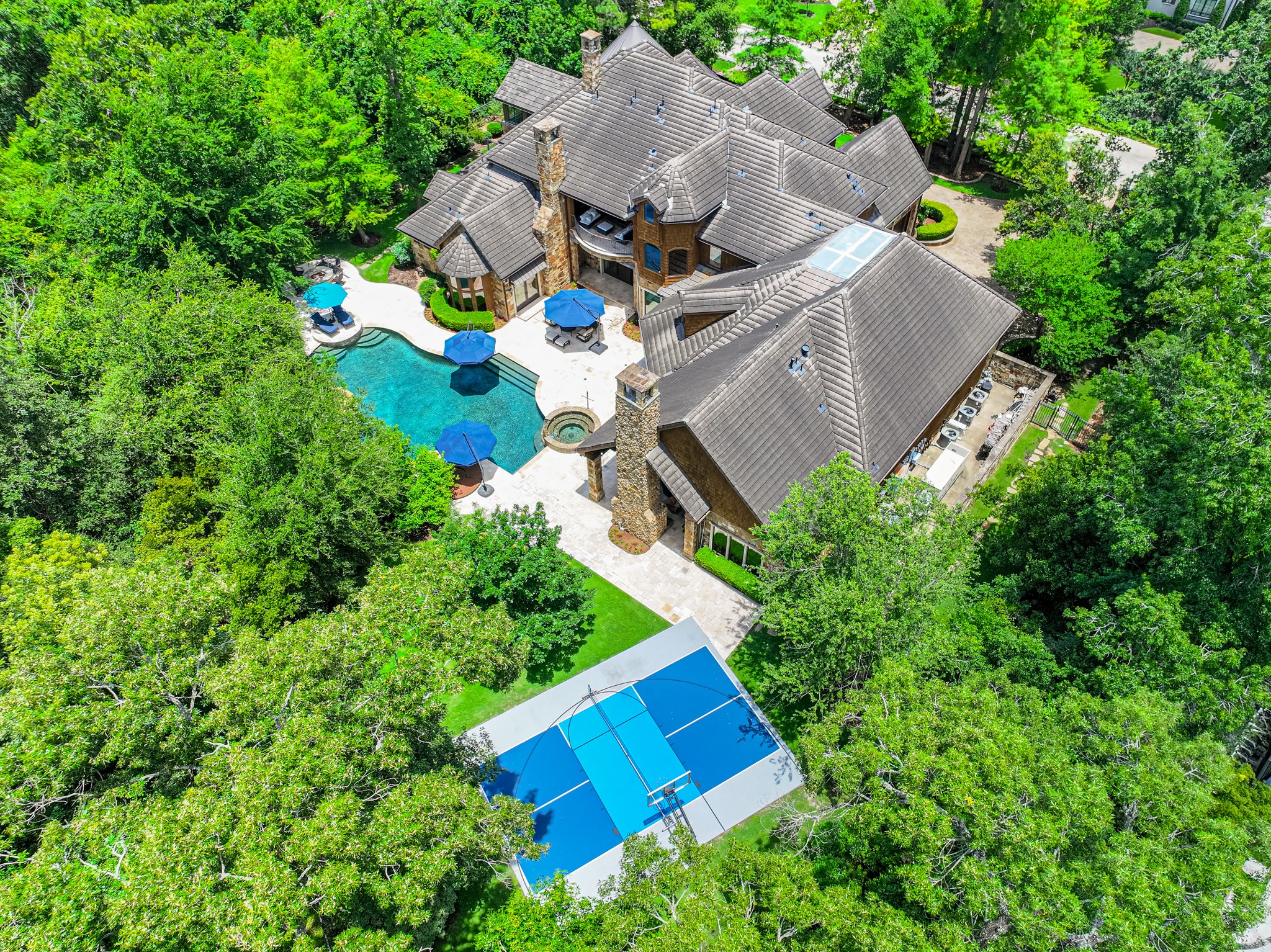 247 South Fazio Way Spring, TX 77389 - Photo 2 of 17 Tucked away on a secluded, tree-lined lot in the prestigious Carlton Woods, this one-of-a-kind estate seamlessly blends luxury, privacy, and resort-style living.