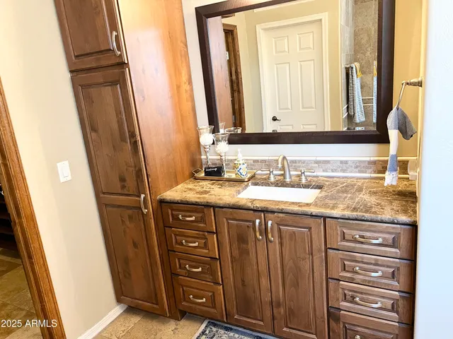 a bathroom with a granite countertop sink and a mirror