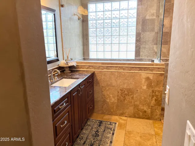 a bathroom with a sink a mirror and a shower