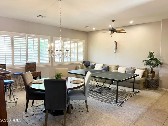 a dining room with furniture a rug and a potted plant