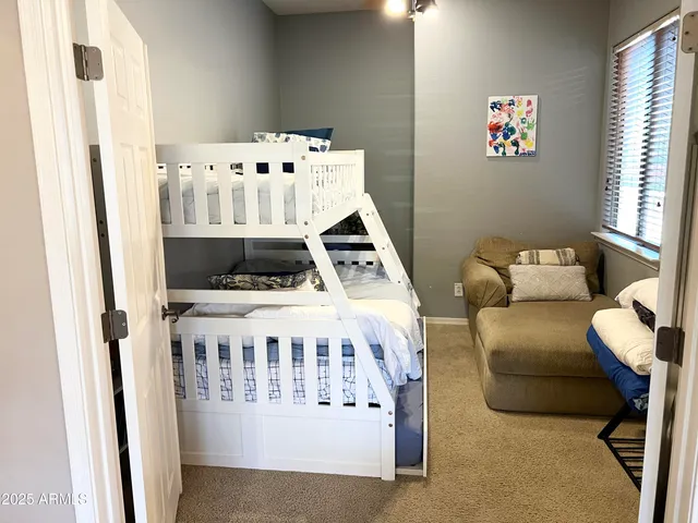 a white bed sitting in a bedroom next to a window