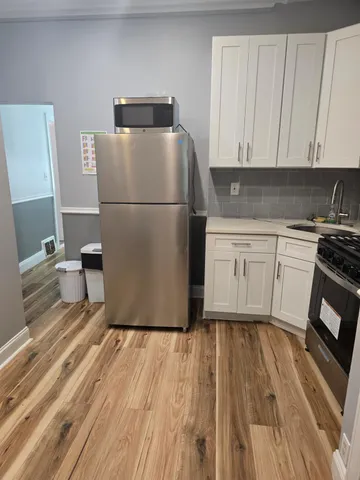 a kitchen with a refrigerator sink and cabinets